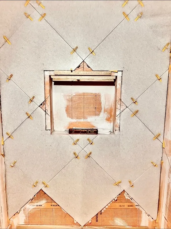 Shower niche remodel before — in-progress diagonal tile with yellow spacers around an open niche by All Beaches Remodeling and Repair